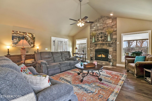 living room featuring ceiling fan, dark hardwood / wood-style flooring, high vaulted ceiling, and a stone fireplace