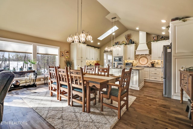 dining room with dark hardwood / wood-style flooring, a skylight, high vaulted ceiling, and a notable chandelier