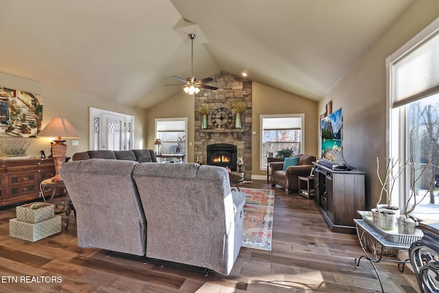 living room featuring a fireplace, vaulted ceiling, ceiling fan, and dark wood-type flooring