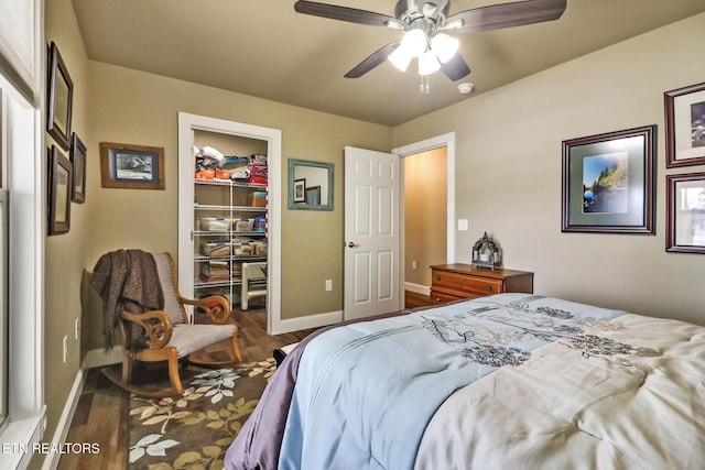 bedroom featuring ceiling fan, dark hardwood / wood-style flooring, a spacious closet, and a closet