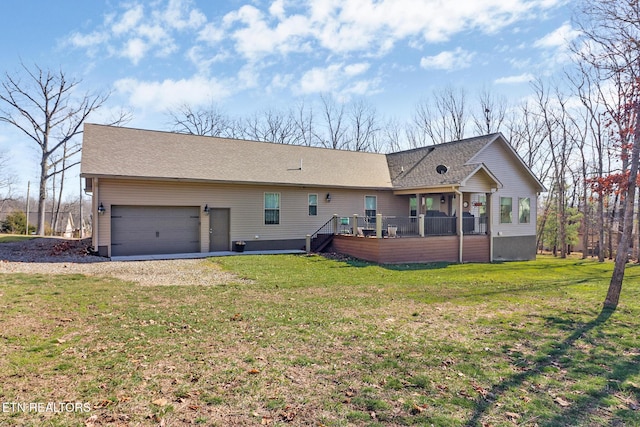 rear view of property with a garage and a lawn