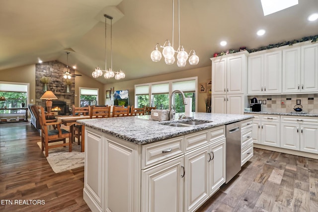 153 Walden Ridge Dr, Fairfield Glade, TN 38558 - kitchen featuring a sink, dishwasher, dark wood-style flooring, vaulted ceiling, and a stone fireplace