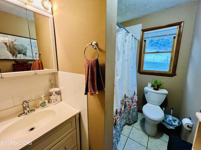 bathroom featuring vanity, tile patterned flooring, toilet, a textured ceiling, and curtained shower