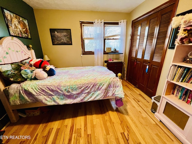 bedroom with light wood-type flooring and a closet