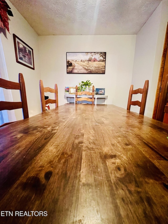 unfurnished dining area with a textured ceiling