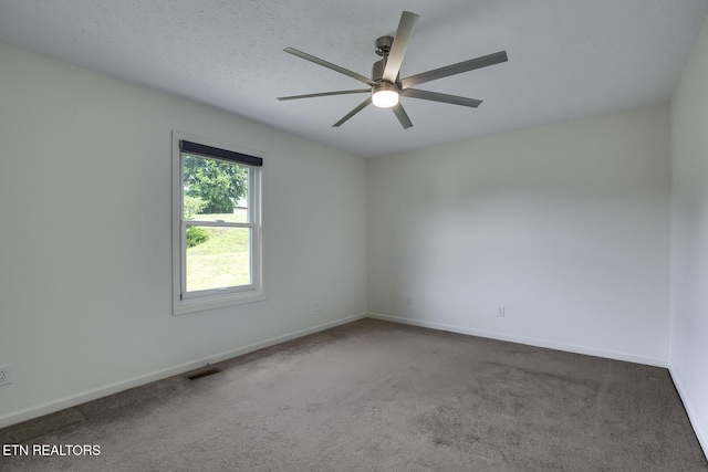 empty room with dark carpet, a textured ceiling, and ceiling fan