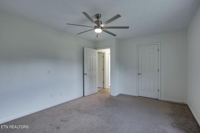 carpeted empty room featuring ceiling fan