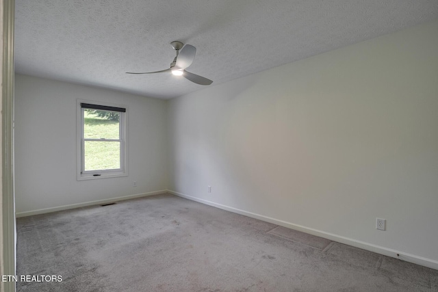 spare room with a textured ceiling, ceiling fan, and light colored carpet