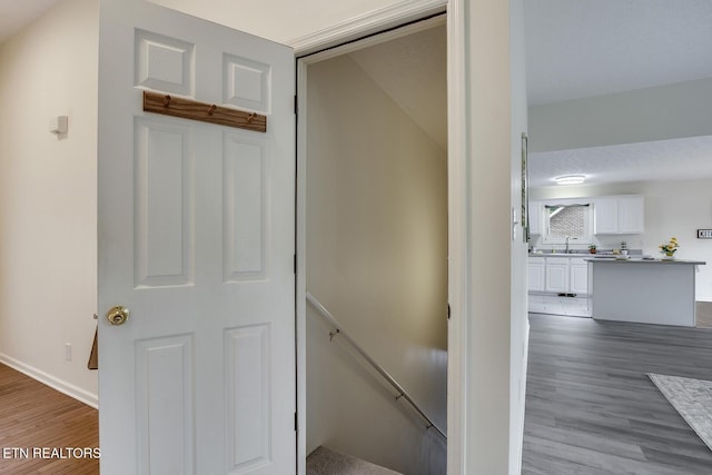 stairs featuring sink and hardwood / wood-style floors