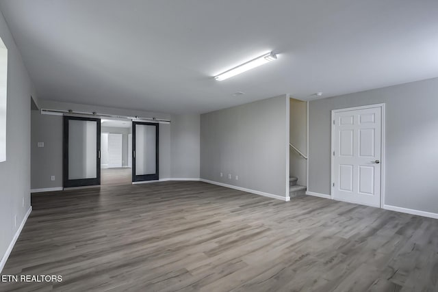 unfurnished room with hardwood / wood-style flooring and a barn door