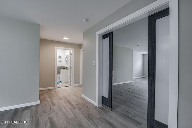 hallway with light hardwood / wood-style floors