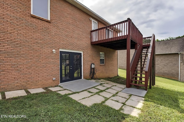 rear view of property with a patio, french doors, a lawn, and a wooden deck