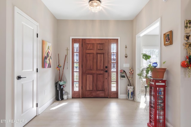 foyer entrance with a chandelier and light hardwood / wood-style flooring