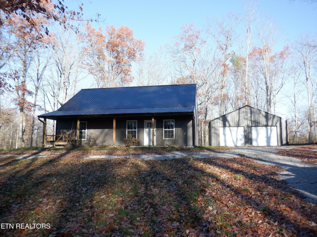 view of front of house with a porch, a garage, and an outdoor structure