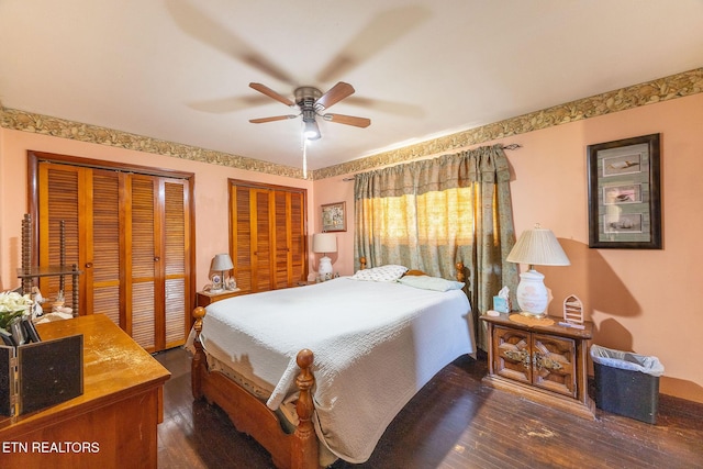 bedroom with two closets, ceiling fan, and dark wood-type flooring