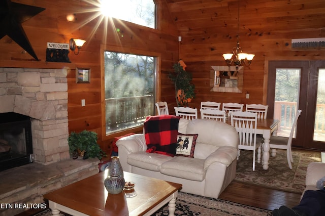 living room with wooden walls, a fireplace, and a wealth of natural light