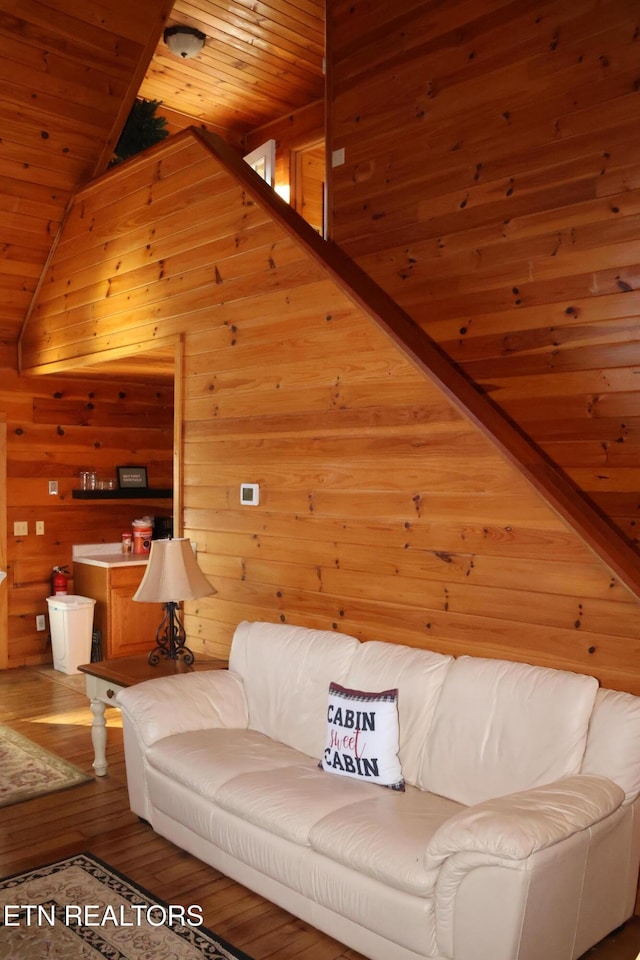 living room featuring wooden ceiling, wood walls, hardwood / wood-style floors, and vaulted ceiling