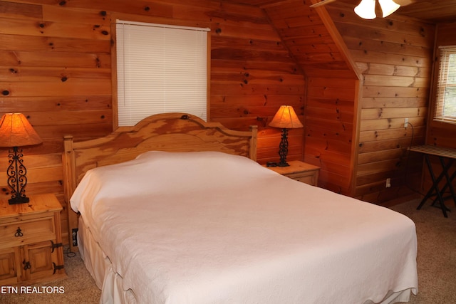 carpeted bedroom featuring wooden walls