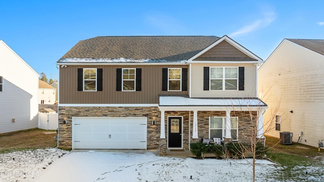 view of front of home with central AC, a garage, and a porch