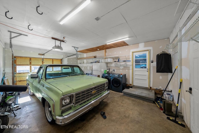 garage with a garage door opener and washing machine and clothes dryer