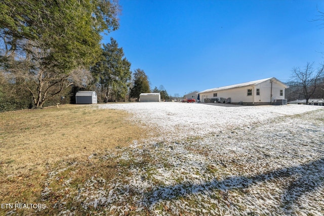 view of yard featuring central AC unit and a storage unit