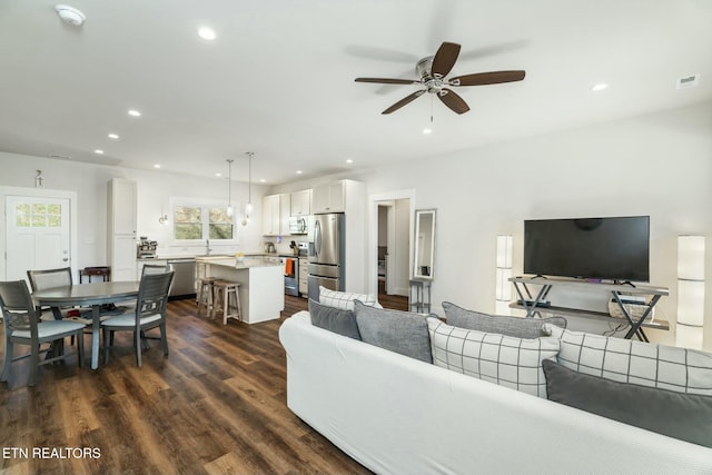 living room featuring ceiling fan and dark hardwood / wood-style floors