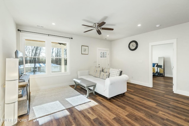 living room with dark wood-type flooring and ceiling fan