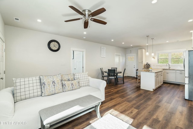 living room featuring sink, ceiling fan, and dark hardwood / wood-style floors