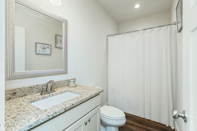 bathroom featuring wood-type flooring, vanity, and toilet