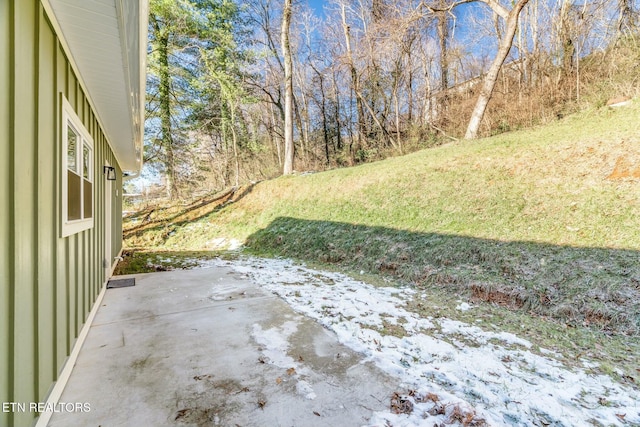 yard covered in snow featuring a patio