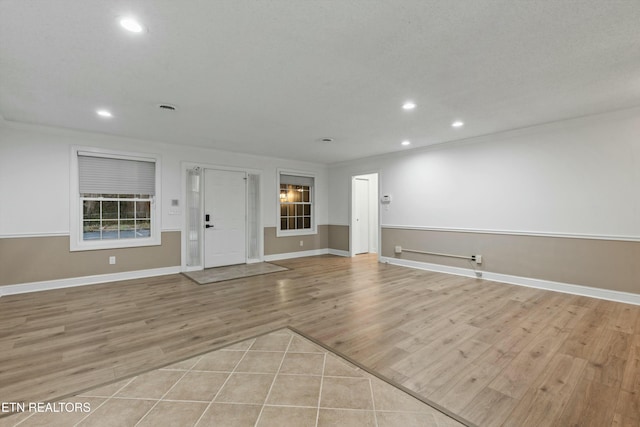 interior space with light wood-type flooring and ornamental molding