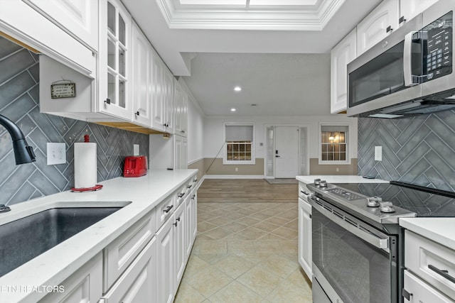 kitchen with sink, white cabinetry, ornamental molding, and appliances with stainless steel finishes