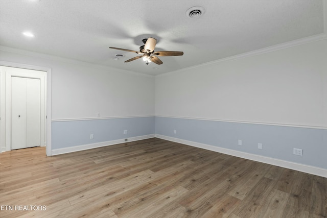 spare room featuring light wood-type flooring, ceiling fan, and ornamental molding