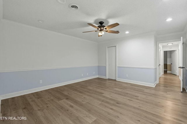 empty room featuring ceiling fan, light hardwood / wood-style floors, and crown molding