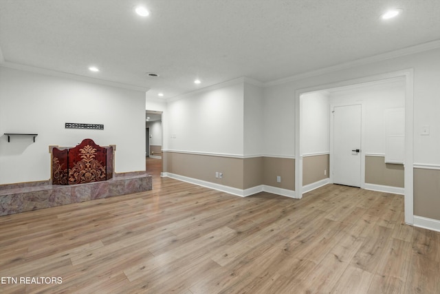 spare room featuring light wood-type flooring and crown molding