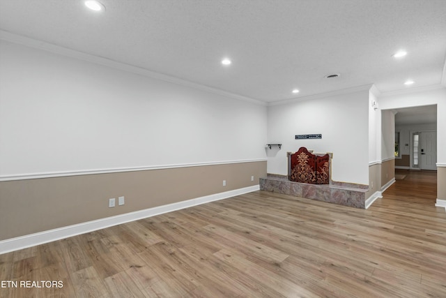 unfurnished living room with ornamental molding and light hardwood / wood-style flooring