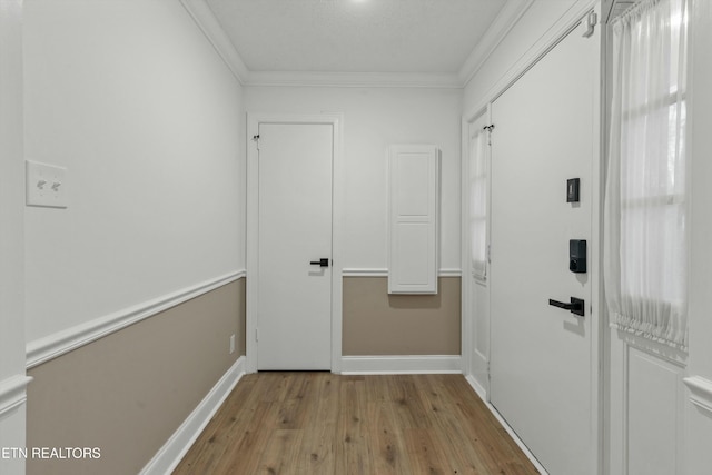 corridor with crown molding and light hardwood / wood-style flooring