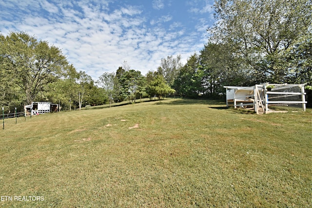 view of yard with an outbuilding and a rural view