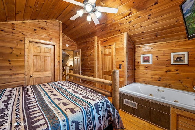 bedroom with hardwood / wood-style flooring, wood walls, lofted ceiling, ceiling fan, and wooden ceiling