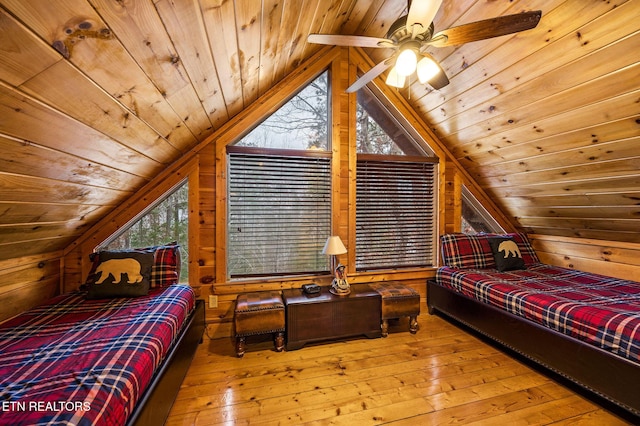 bedroom with vaulted ceiling, ceiling fan, wood-type flooring, wood walls, and wood ceiling