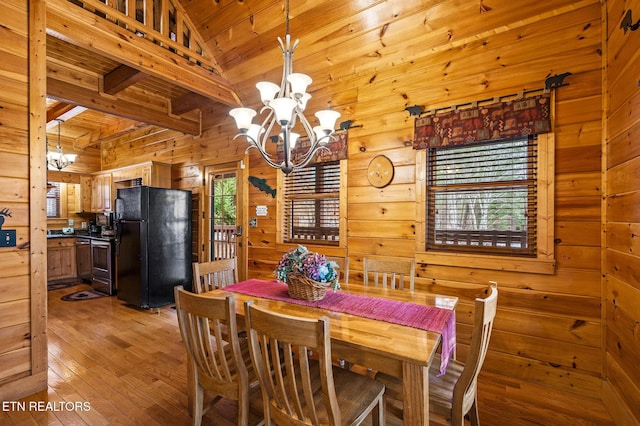 dining area featuring wooden walls, wooden ceiling, an inviting chandelier, vaulted ceiling with beams, and light hardwood / wood-style flooring