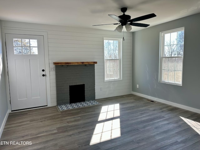 unfurnished living room with ceiling fan, dark hardwood / wood-style flooring, and a fireplace