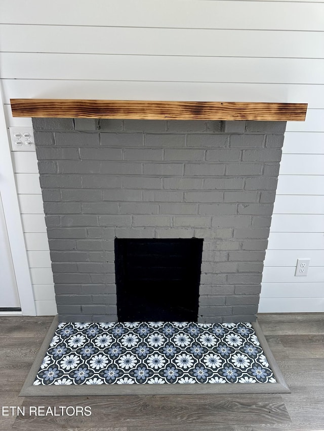 room details featuring wood-type flooring and a brick fireplace