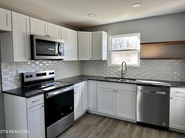 kitchen with sink, white cabinetry, decorative backsplash, dark hardwood / wood-style floors, and appliances with stainless steel finishes