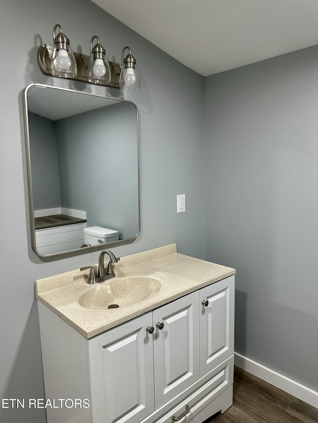 bathroom featuring hardwood / wood-style floors, toilet, and vanity