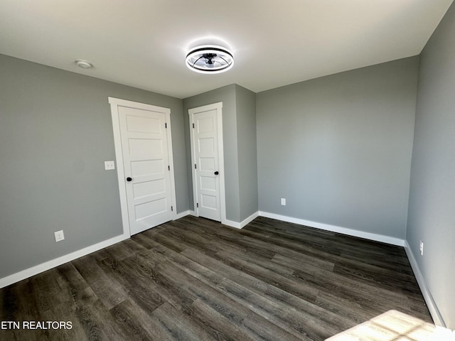 unfurnished bedroom with dark wood-type flooring