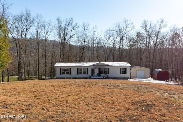 ranch-style home featuring a front lawn, covered porch, and a storage unit