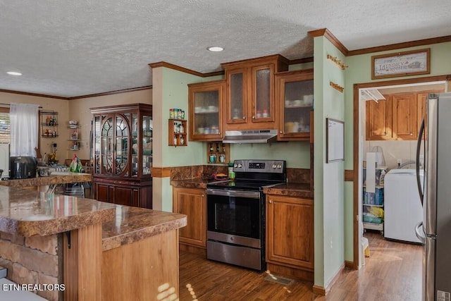 kitchen with washer / dryer, kitchen peninsula, appliances with stainless steel finishes, a textured ceiling, and dark hardwood / wood-style flooring