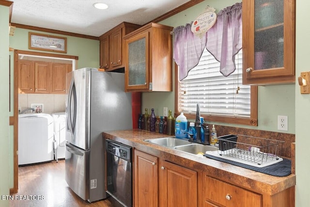 kitchen with washer and dryer, crown molding, black dishwasher, and light hardwood / wood-style flooring