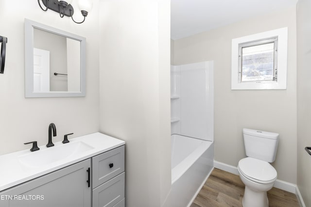 full bathroom with hardwood / wood-style flooring, vanity, shower / washtub combination, and toilet